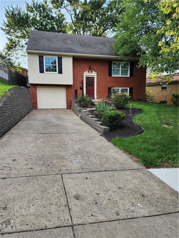 a front view of a house with a yard and a garage