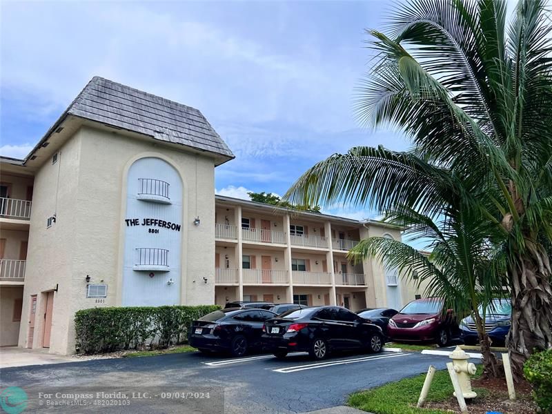 a front view of a residential apartment building with a garden