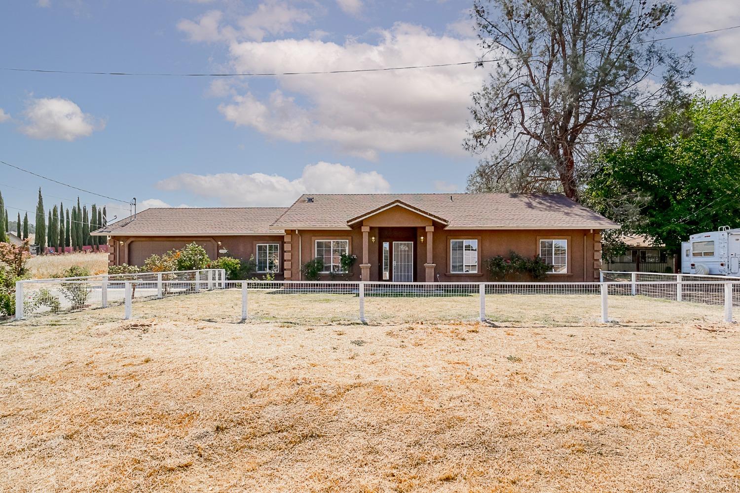 a front view of house with yard covered in snow