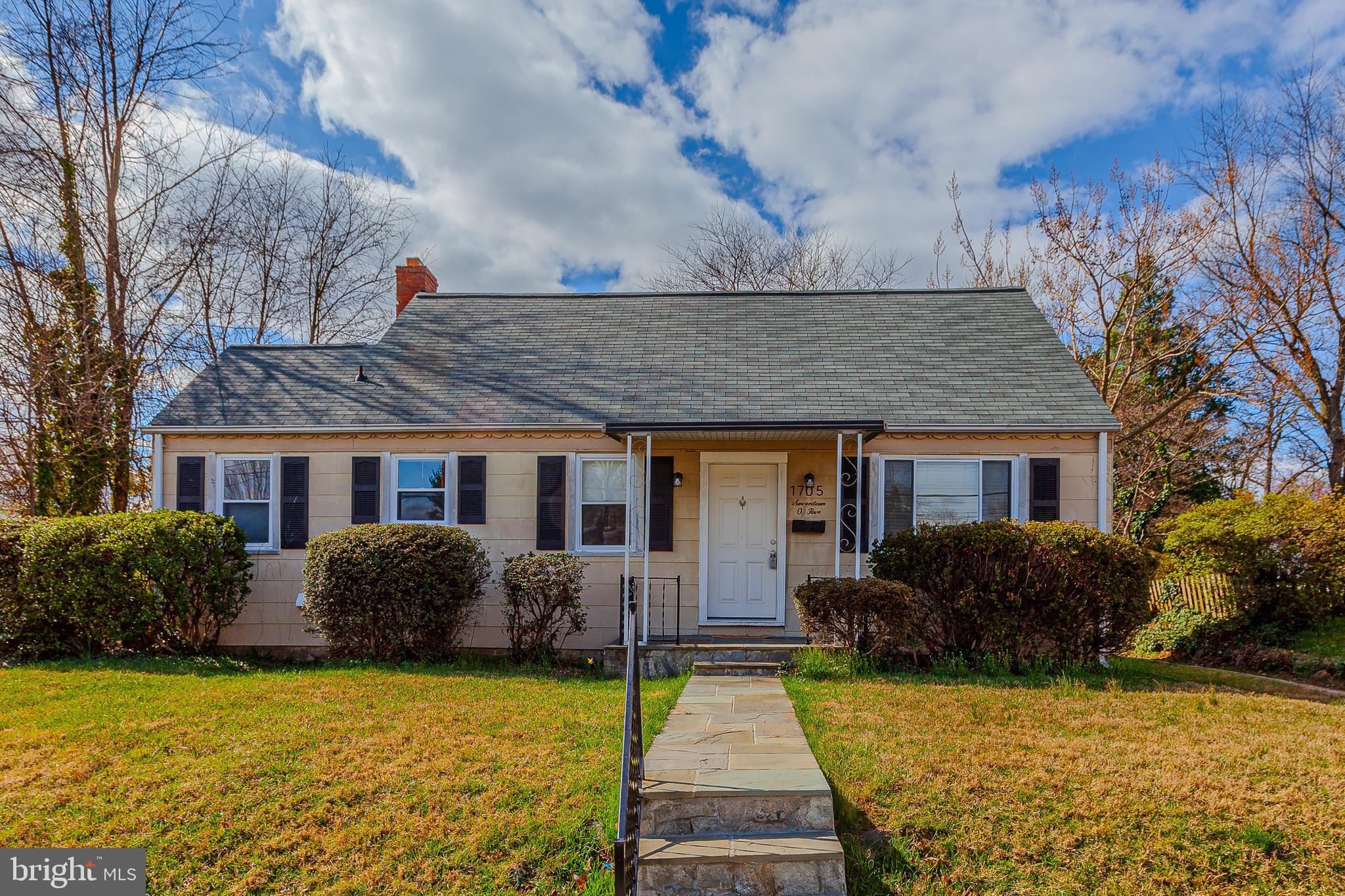 a front view of house with yard and trees around