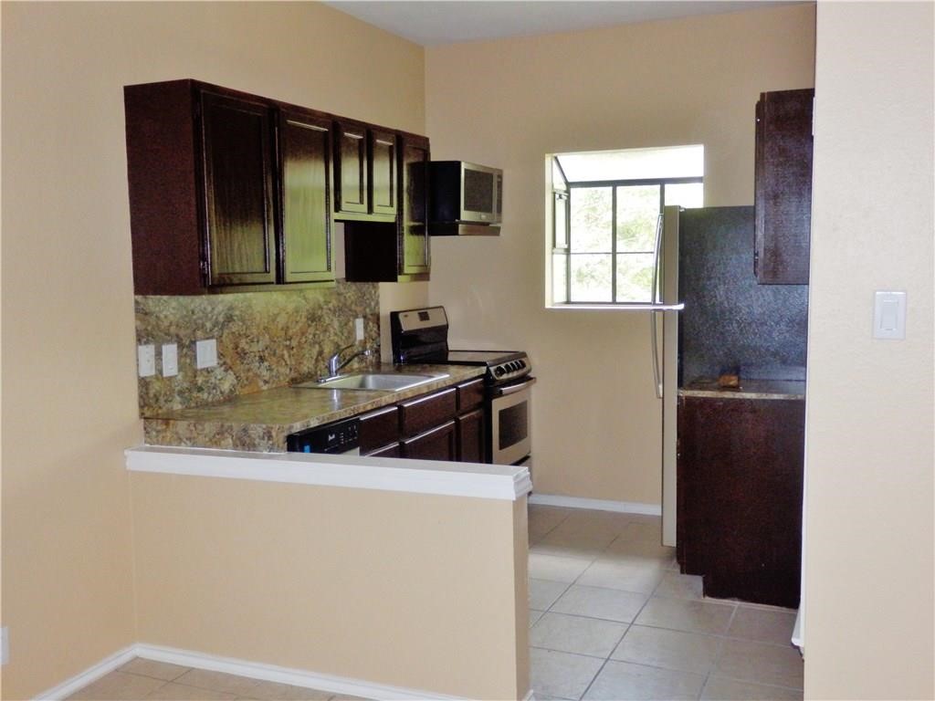 a kitchen with a refrigerator and a stove top oven