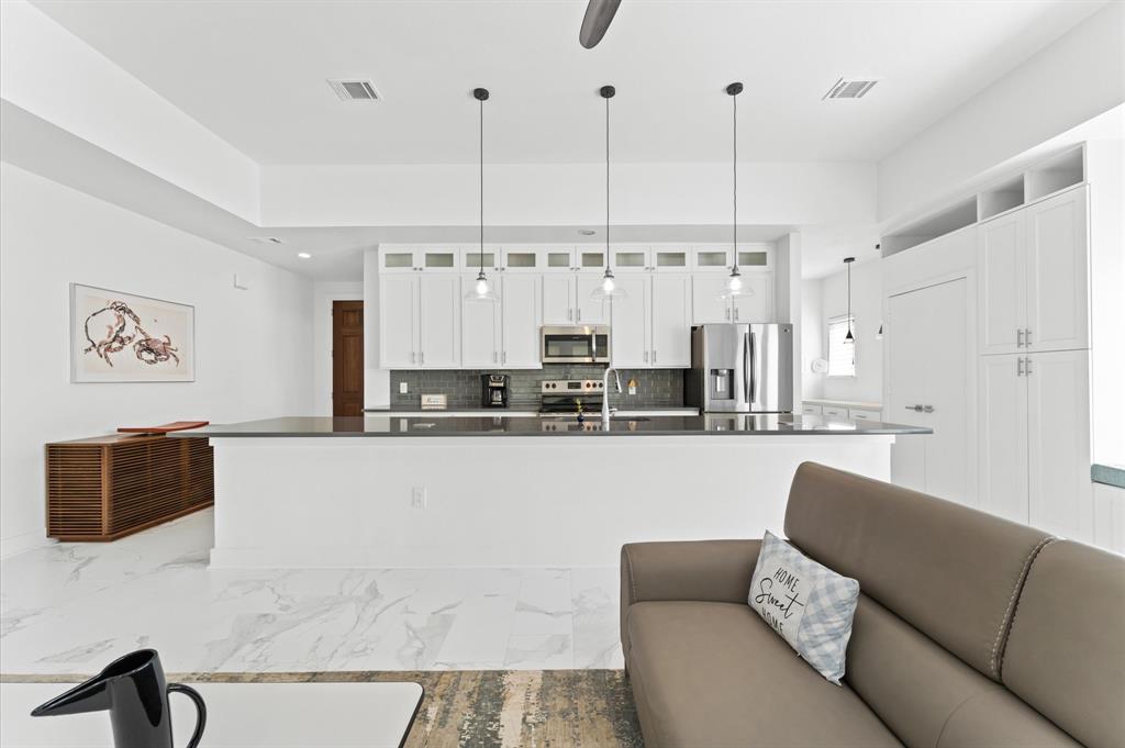 a living room with stainless steel appliances kitchen island granite countertop furniture and a view of kitchen