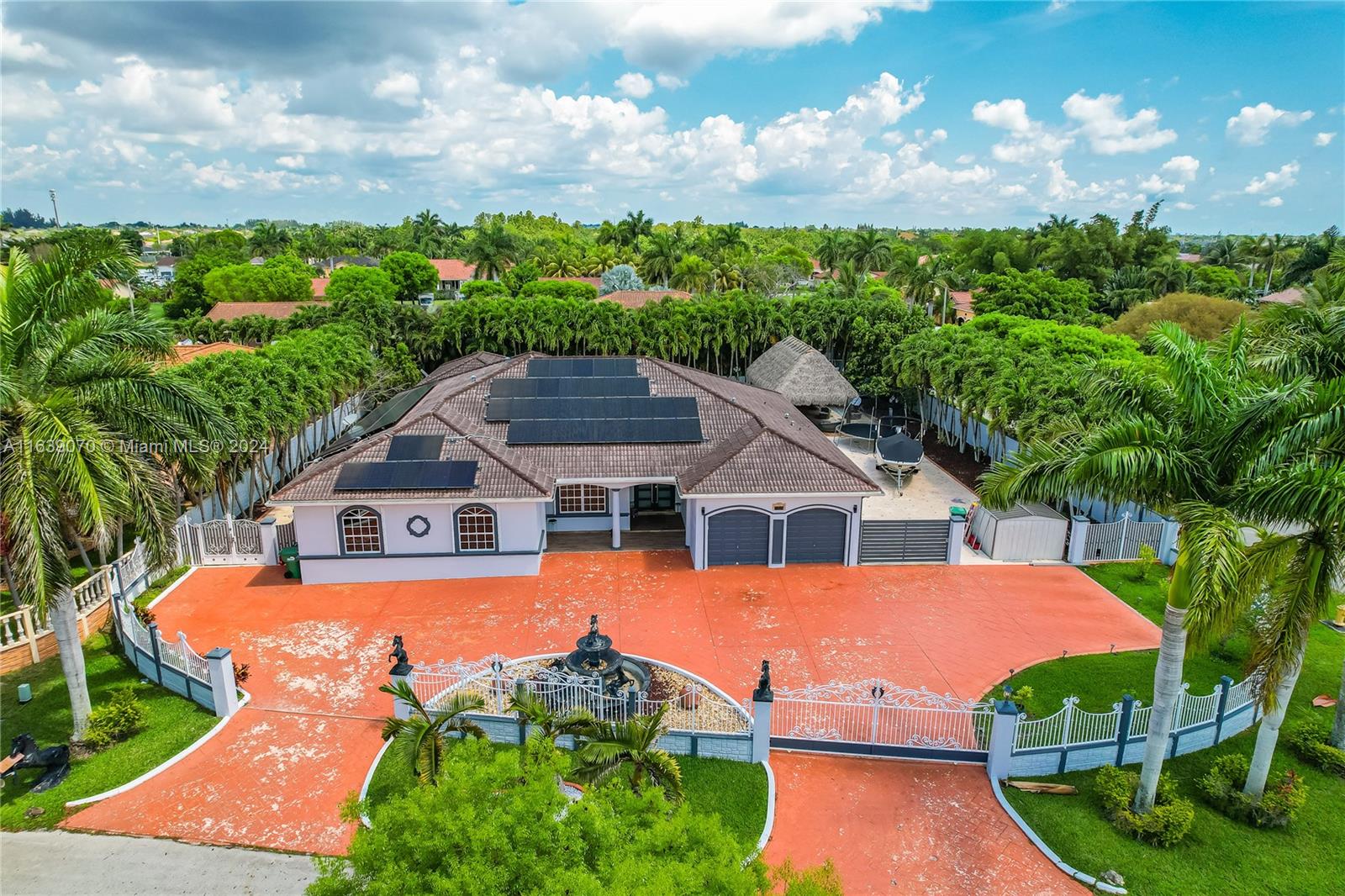 an aerial view of a house with a garden and lake view