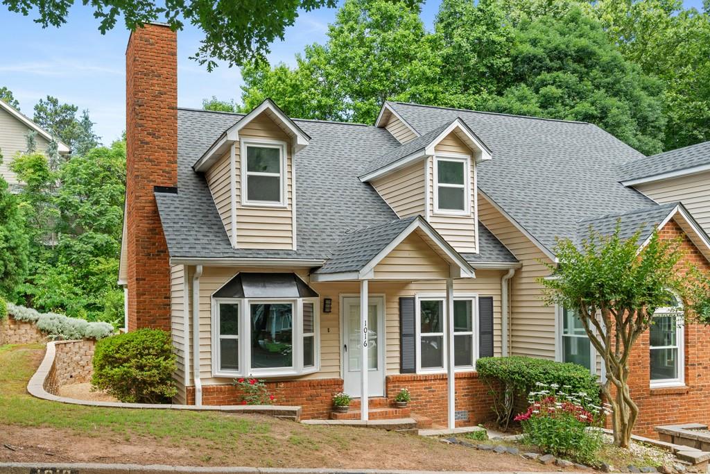 a front view of a house with a yard and potted plants