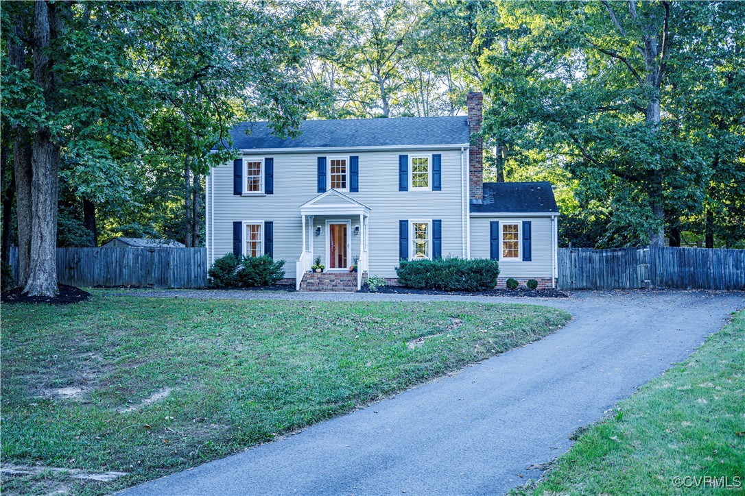 a front view of a house with a yard and tree