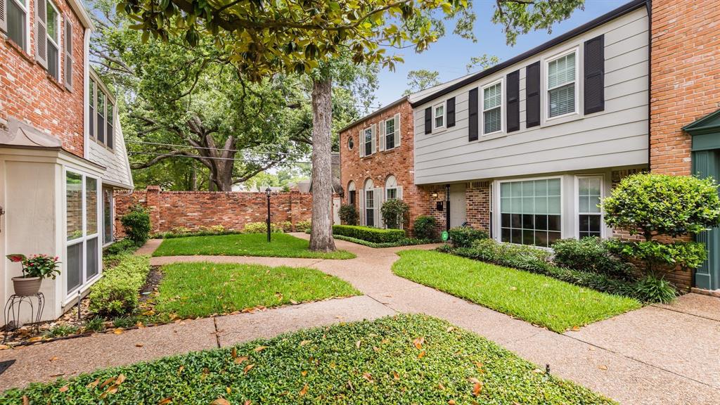 a front view of a house with a yard and potted plants