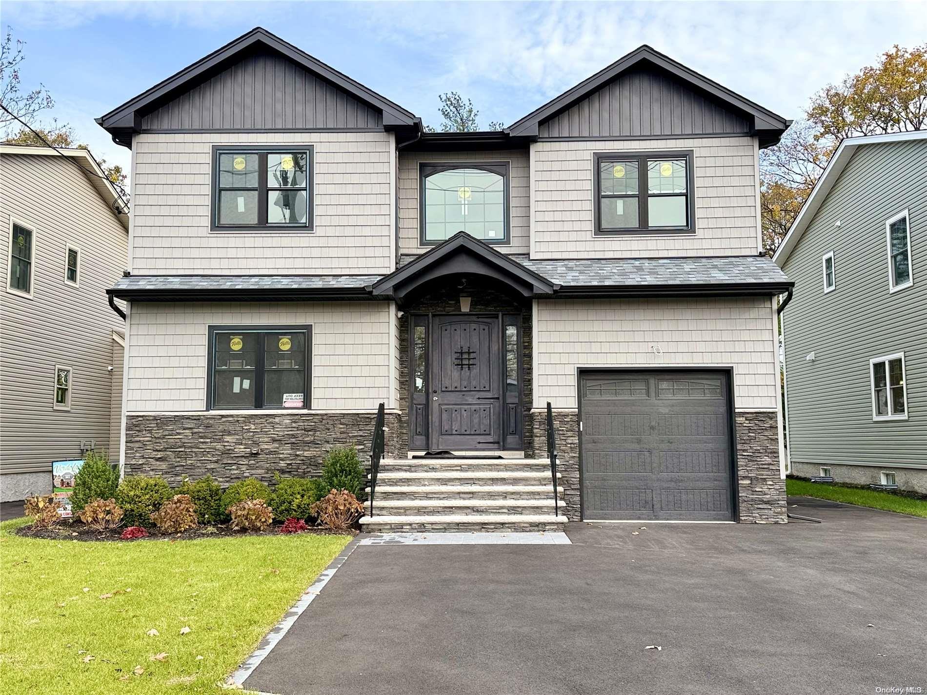 a front view of a house with a garden and garage