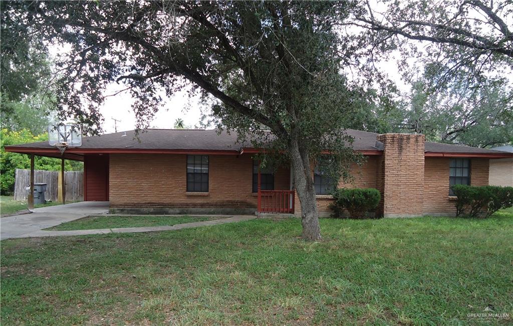 Single story home featuring a front lawn and a carport