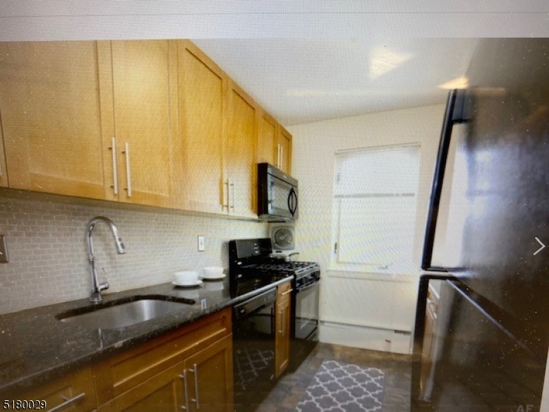 a kitchen with sink a refrigerator and cabinets