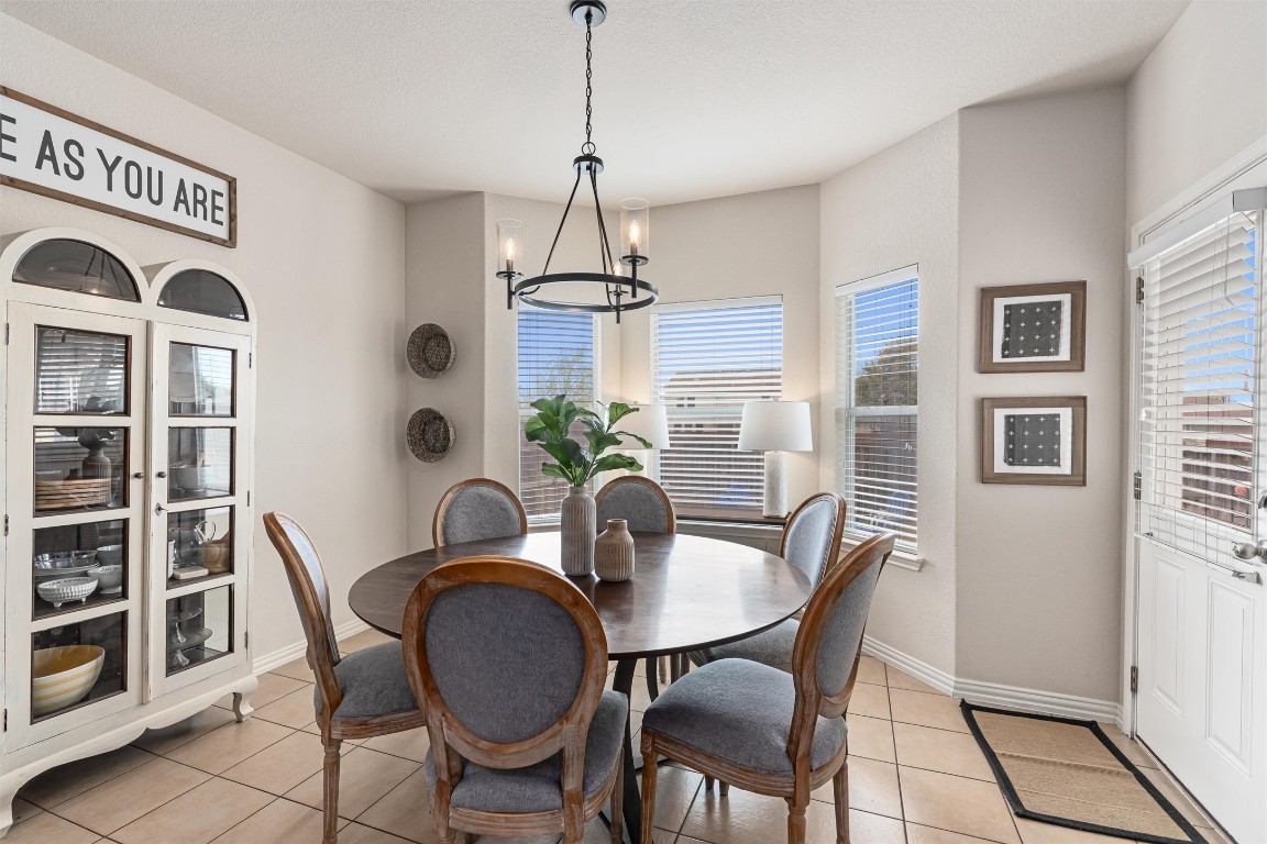 a dining room with furniture a chandelier and window