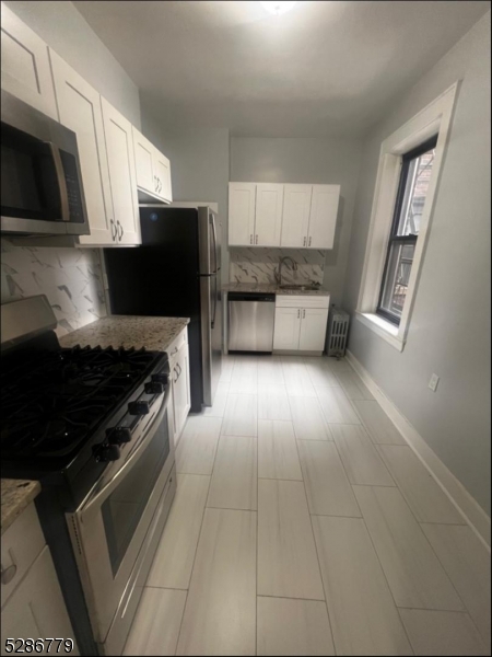 a kitchen with granite countertop a stove and a microwave