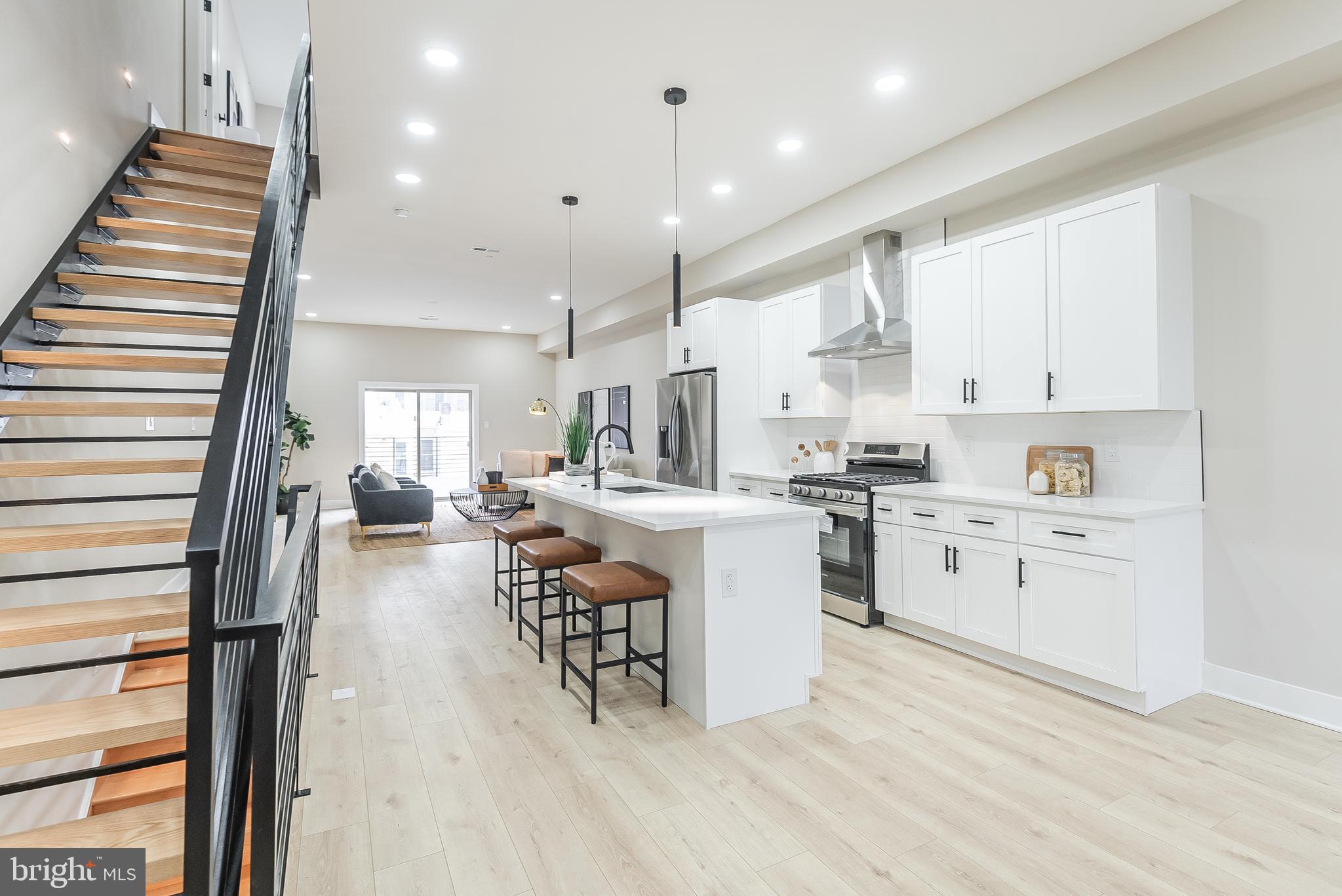 a kitchen with white cabinets and chairs