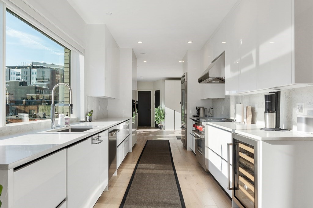 a large kitchen with stainless steel appliances lots of counter space and a sink