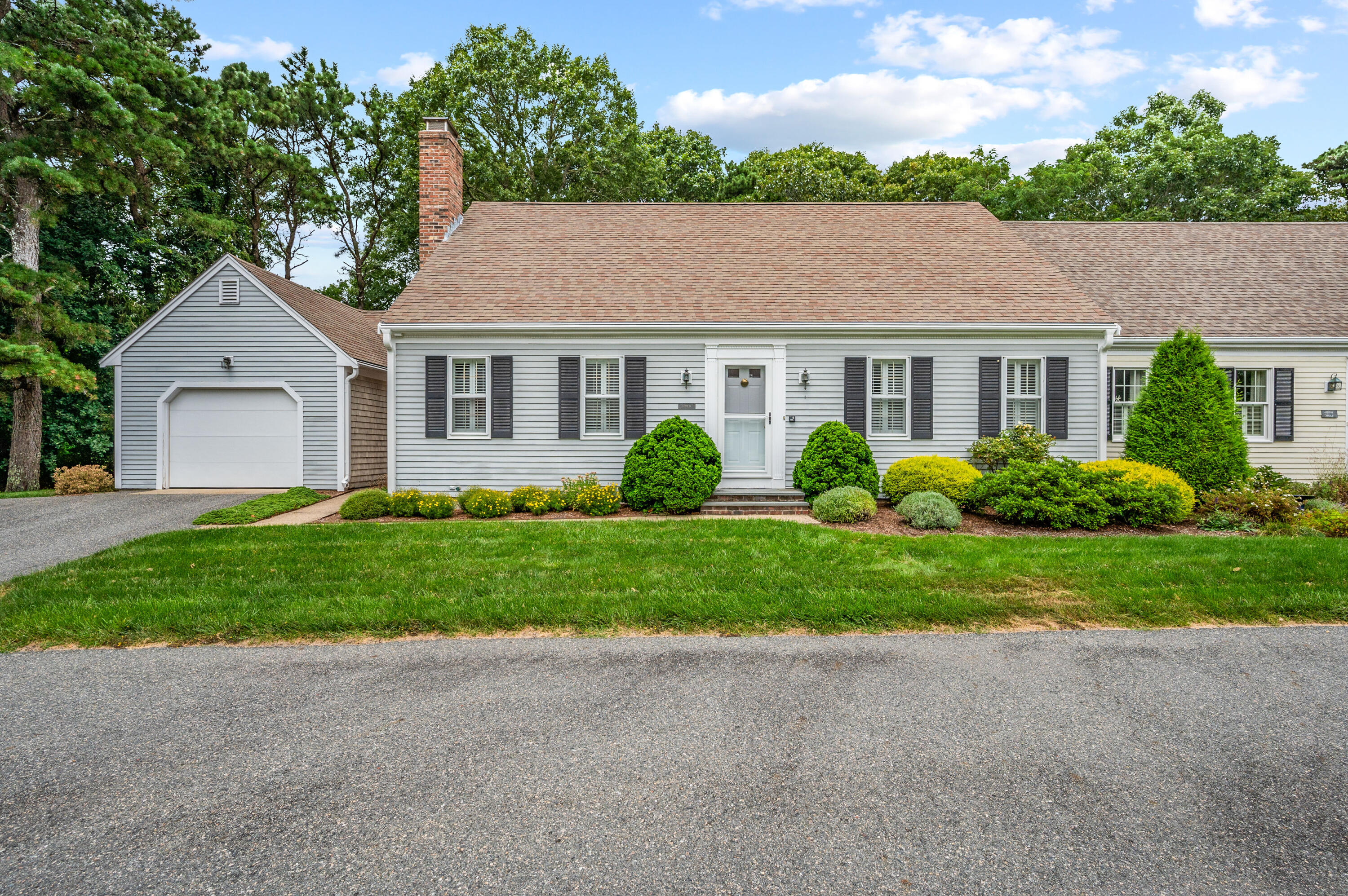 a view of a house with a yard and large trees