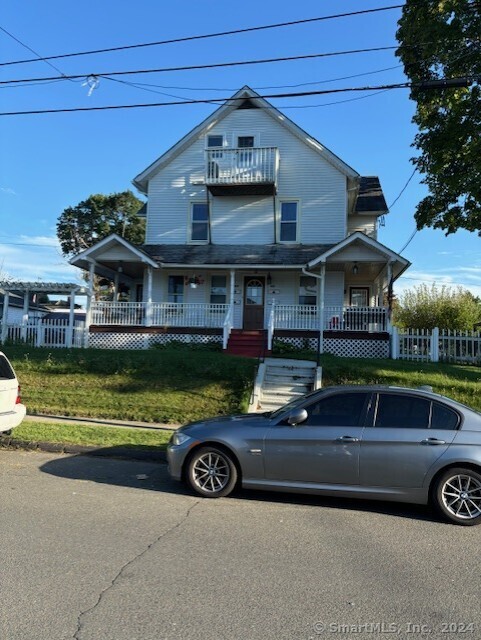 a front view of a house with a garden and lake view