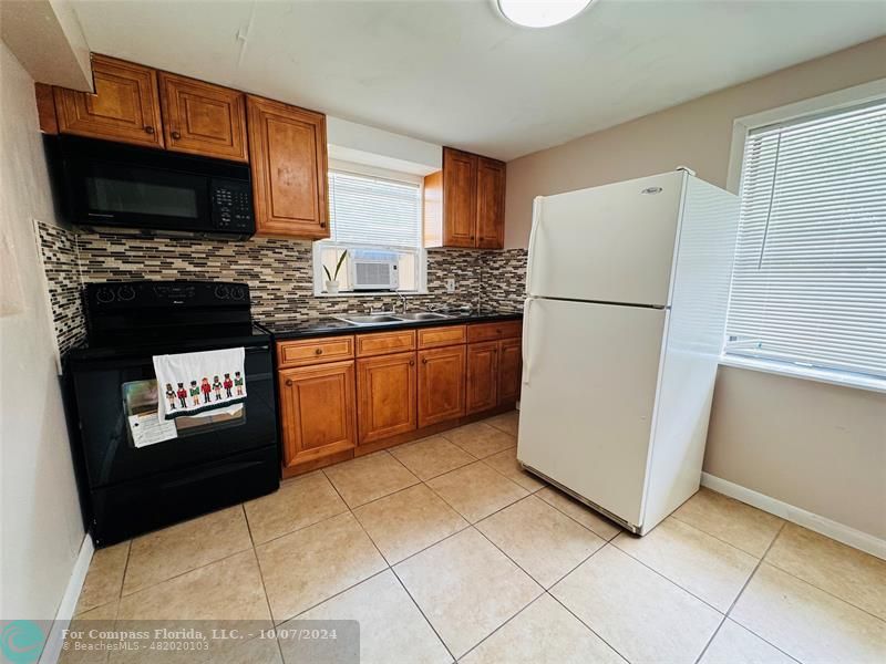 a kitchen with stainless steel appliances granite countertop a refrigerator stove a sink and a microwave