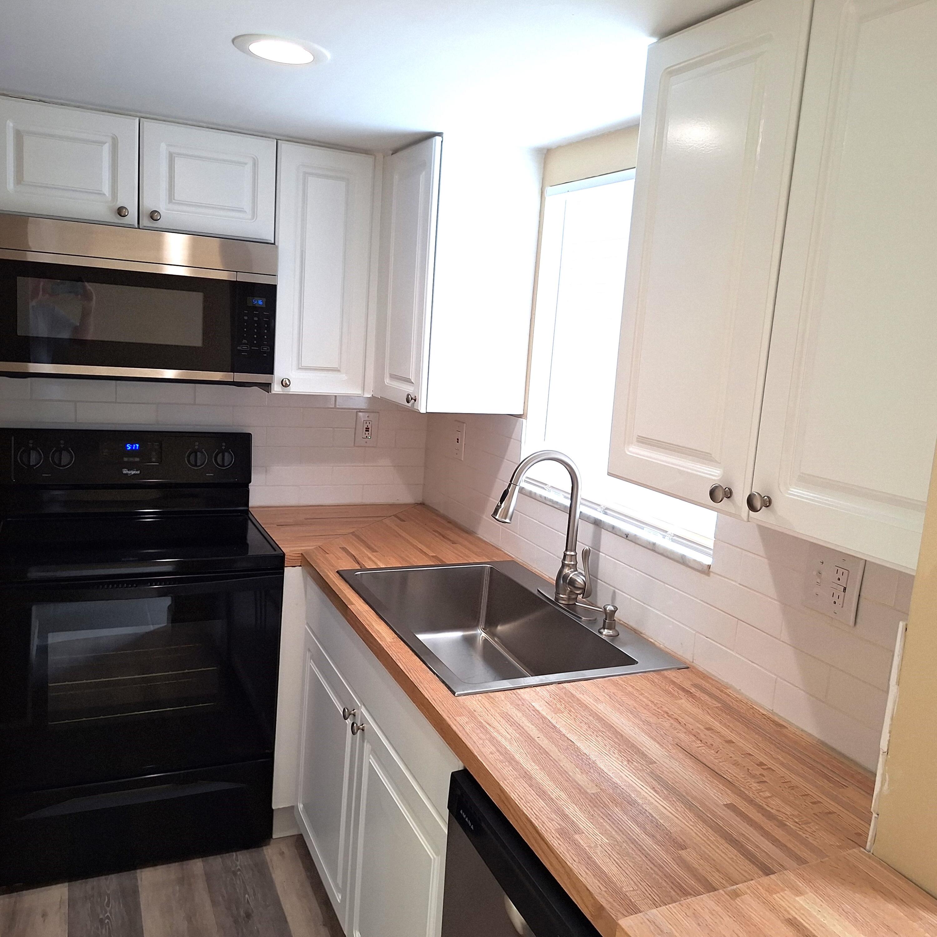 a kitchen with granite countertop a sink and a stove top oven