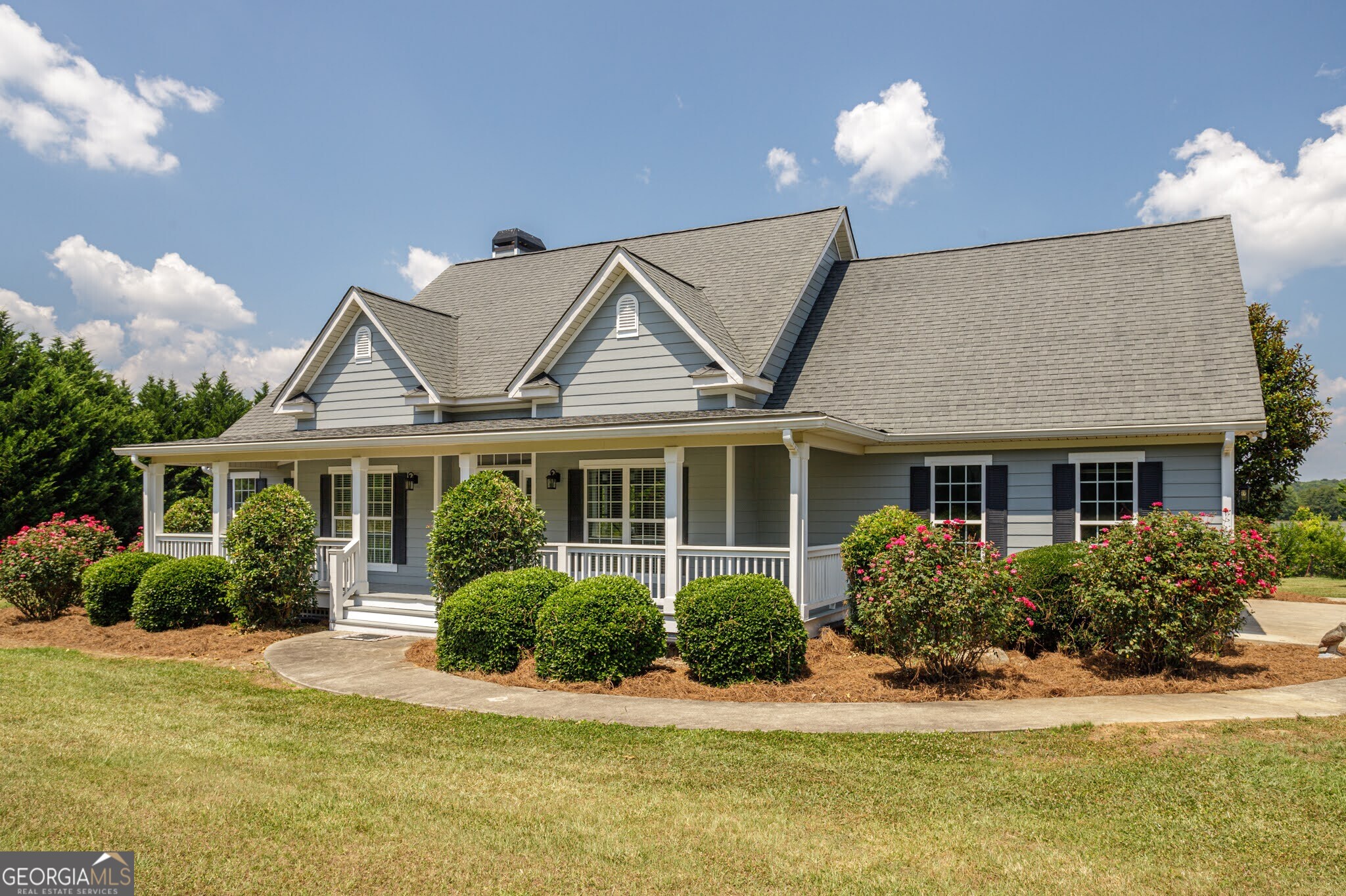 a front view of a house with a yard and potted plants