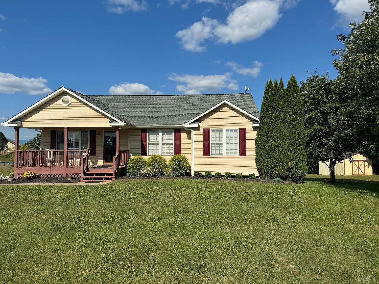 a front view of a house with a garden and trees