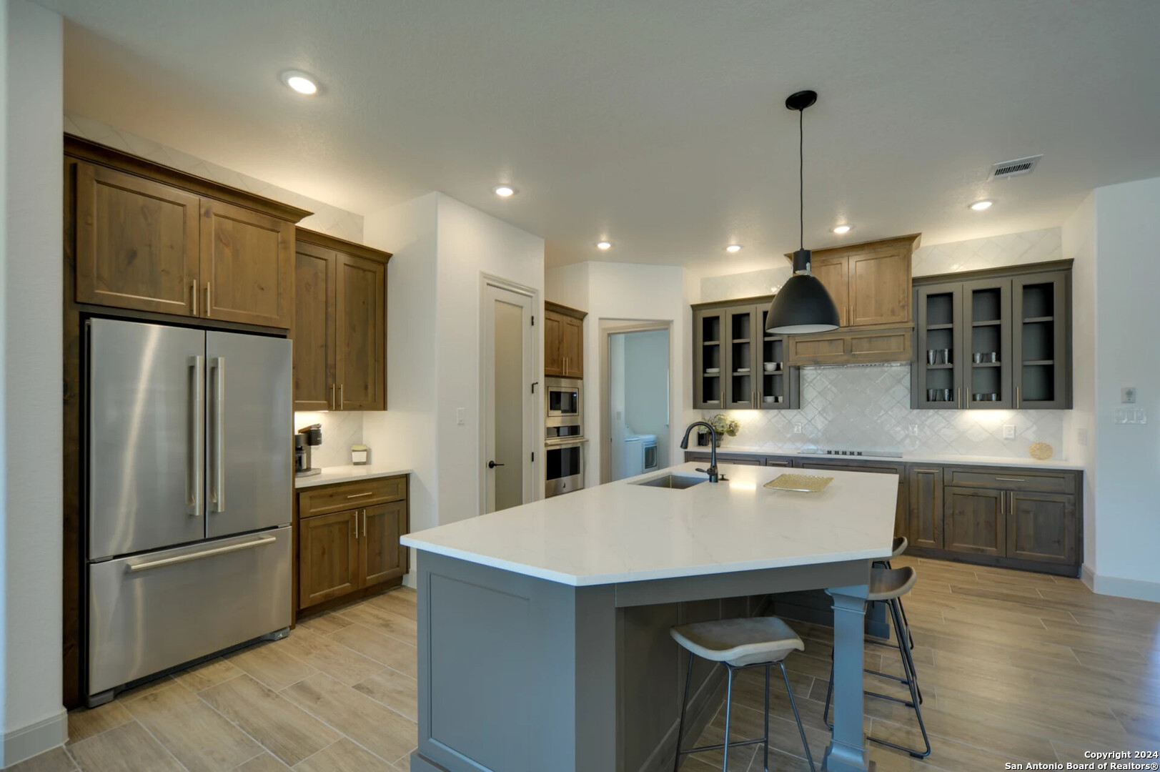 a kitchen with kitchen island a refrigerator stove microwave and cabinets