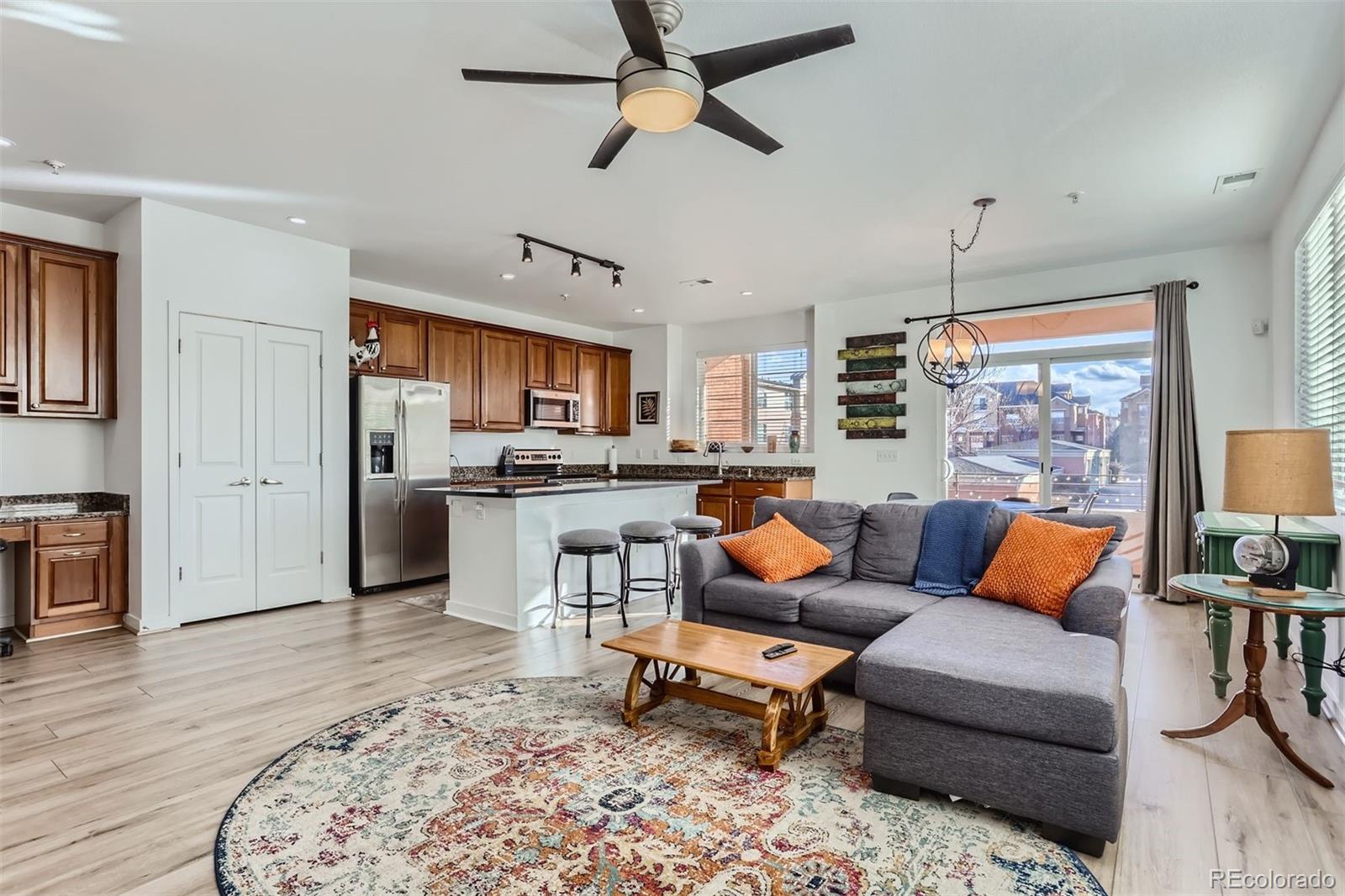 a living room with furniture kitchen view and a large window