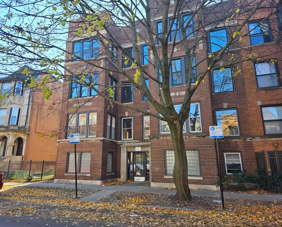 a front view of a residential apartment building with a yard