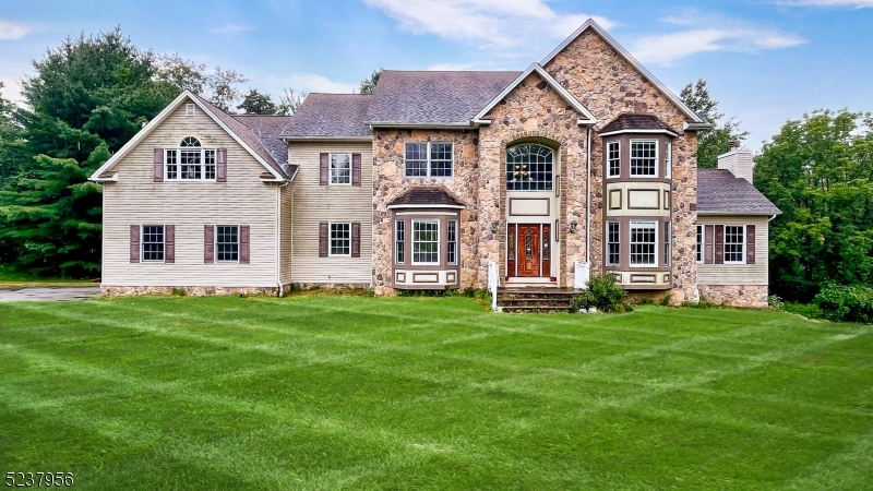 a view of a yard in front of a house with large windows