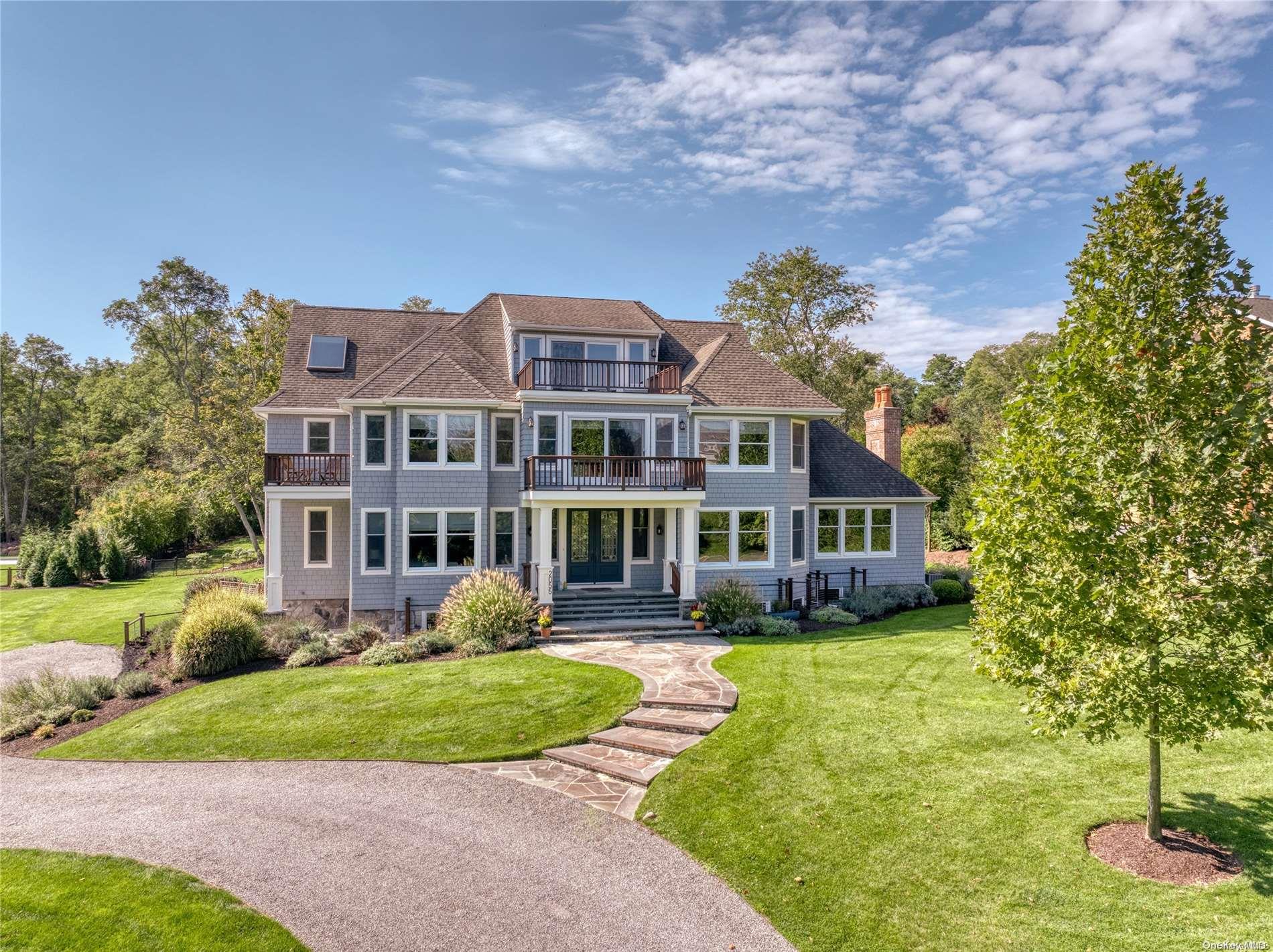 a front view of a house with a garden and trees