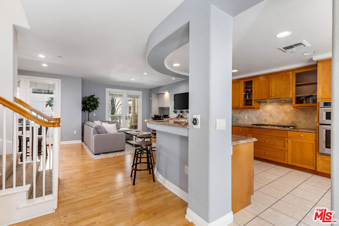 a kitchen with stainless steel appliances granite countertop a refrigerator and a stove top oven