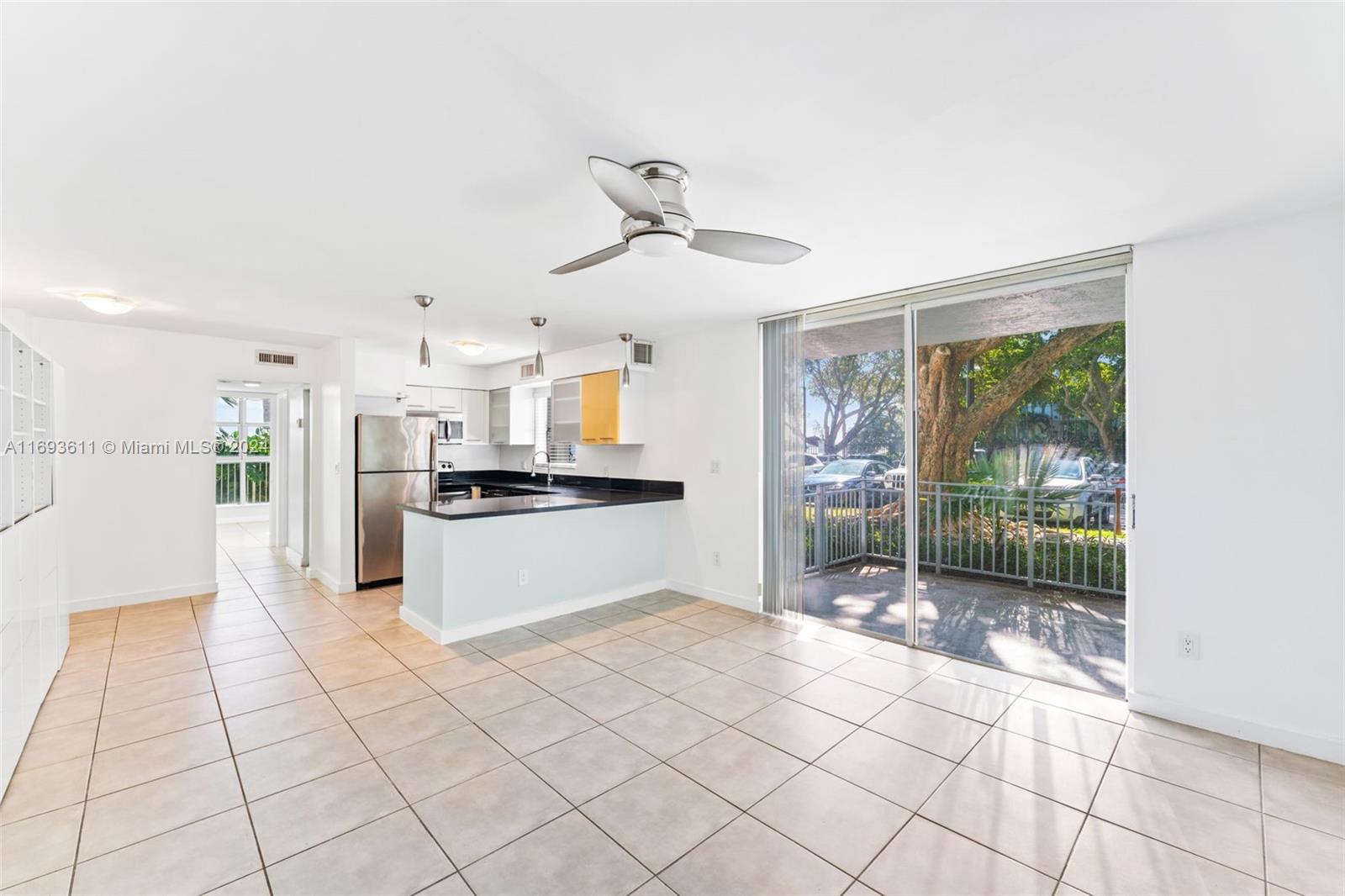 a large white kitchen with white cabinets and refrigerator