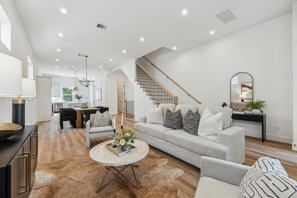 a living room with furniture and a dining table with kitchen view