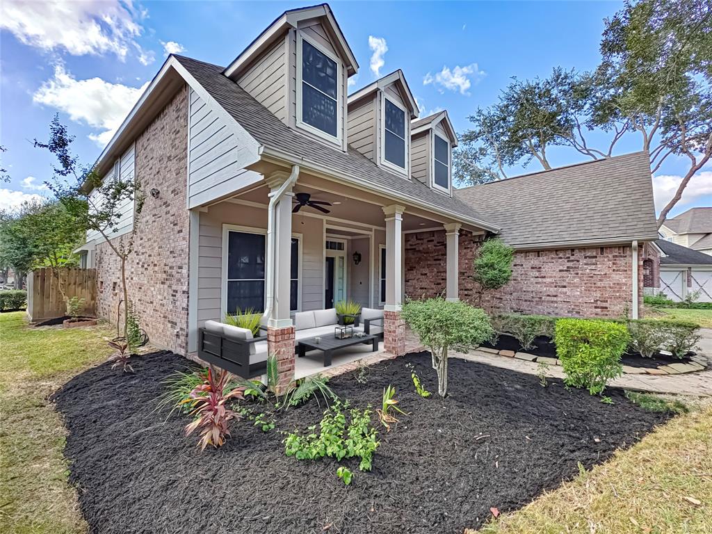 a view of a house with backyard sitting area and garden