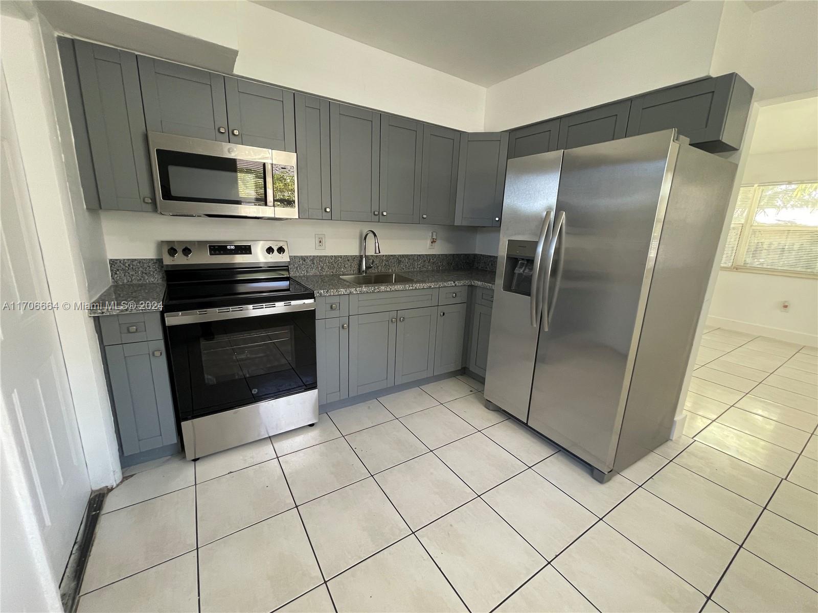 a kitchen with stainless steel appliances granite countertop a refrigerator and a stove top oven