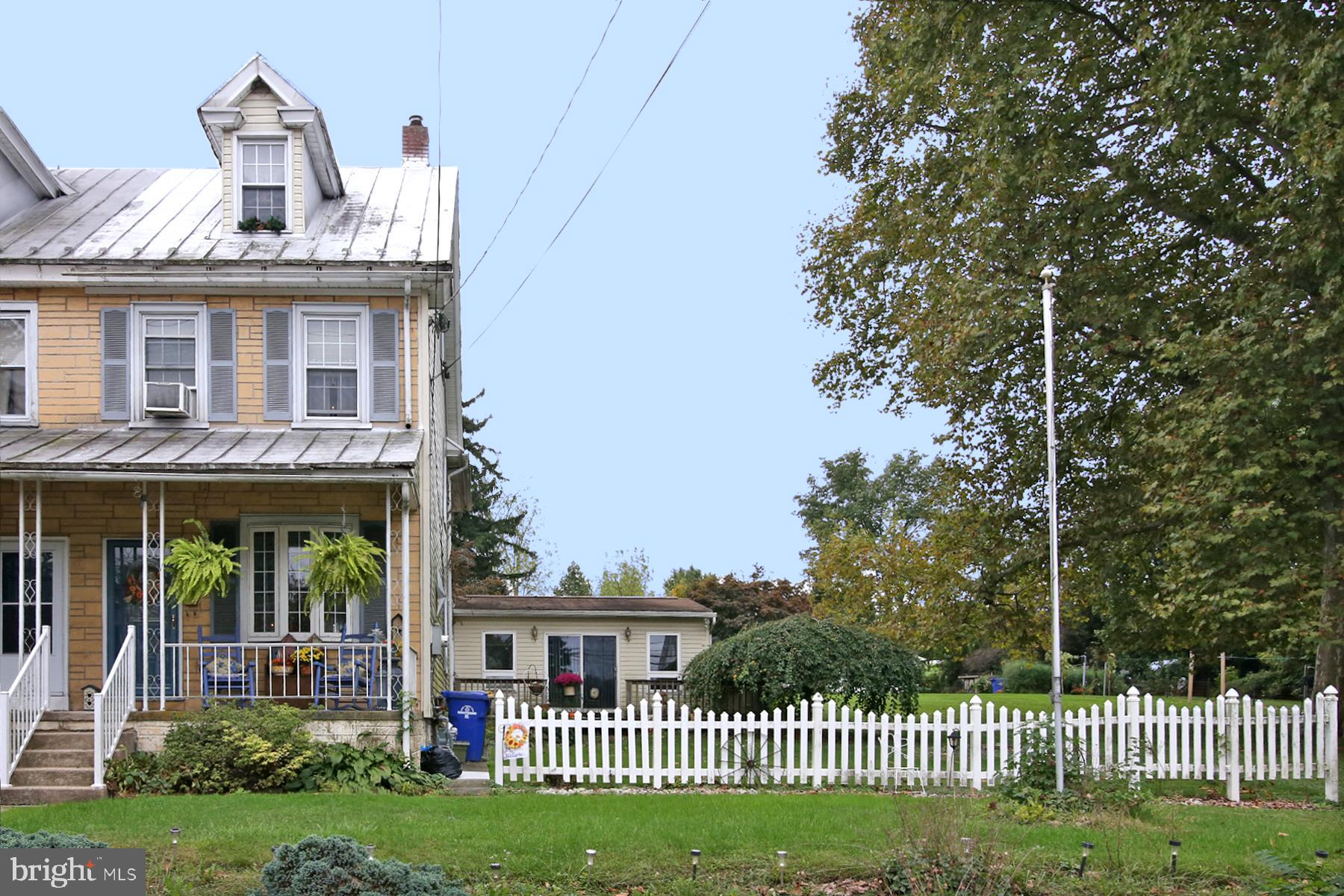 a view of a brick house with a small yard and plants