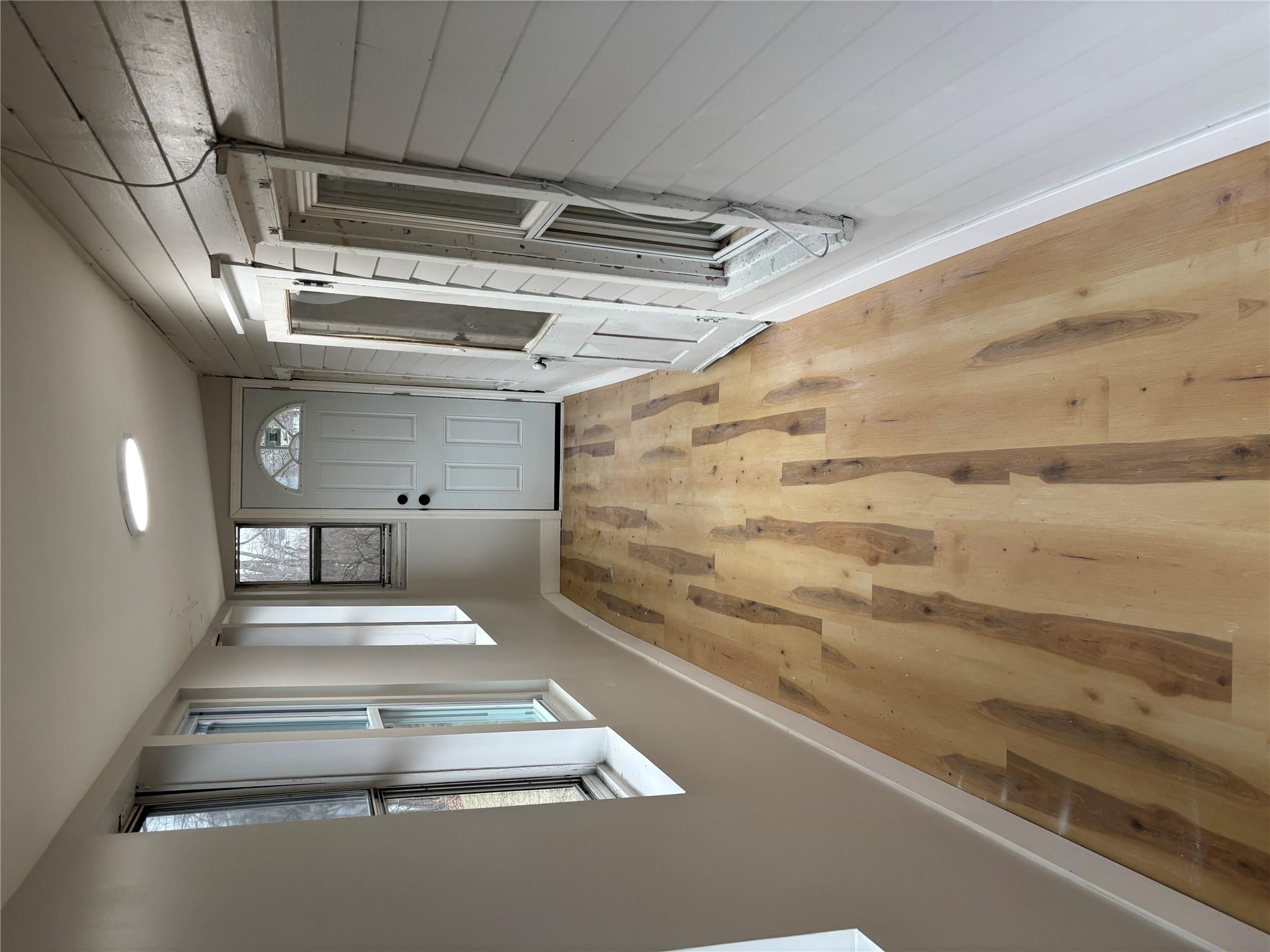 Doorway to outside featuring a barn door, light hardwood / wood-style floors, and wood walls