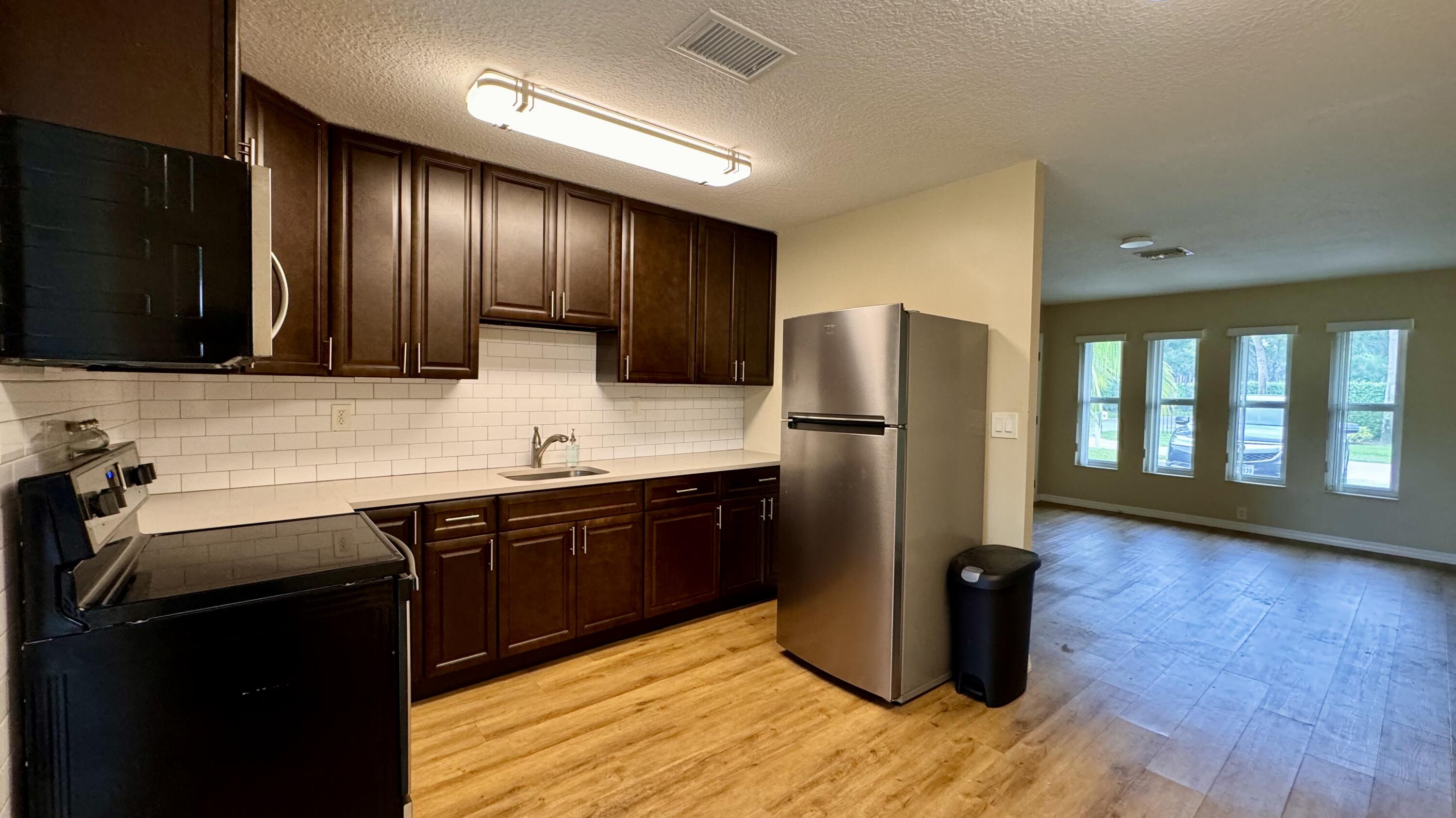 a kitchen with stainless steel appliances granite countertop a refrigerator and a sink