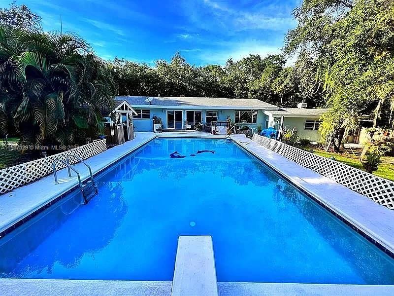 a view of a house with pool and deck