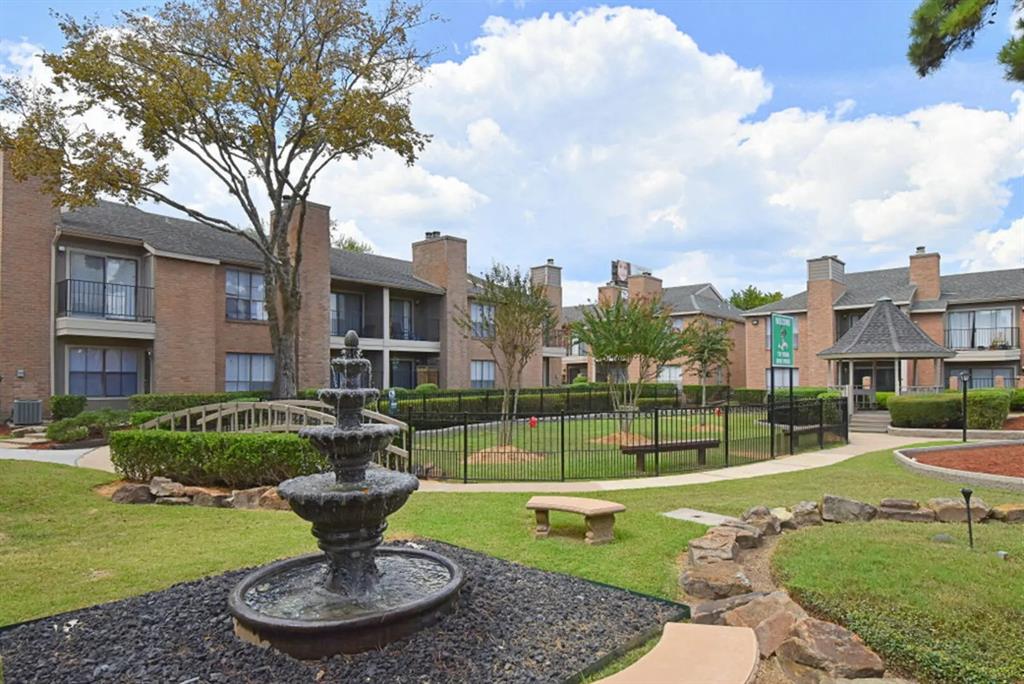 a view of a fountain in front of a brick house with a fountain