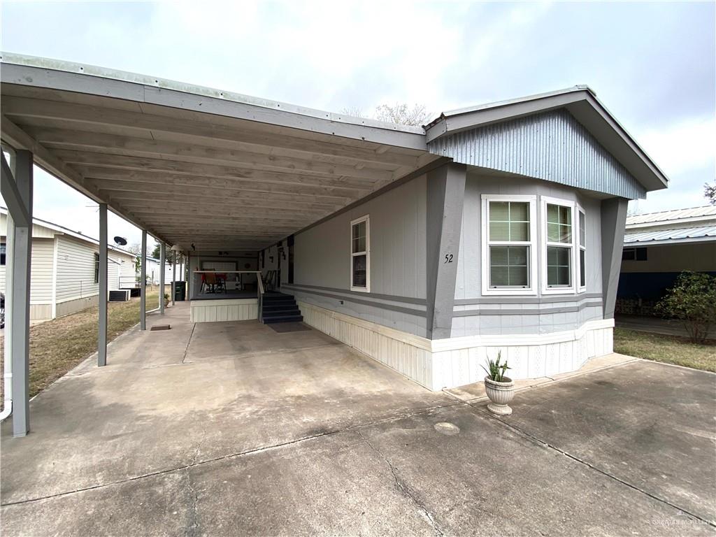 a view of a house with a patio and a yard