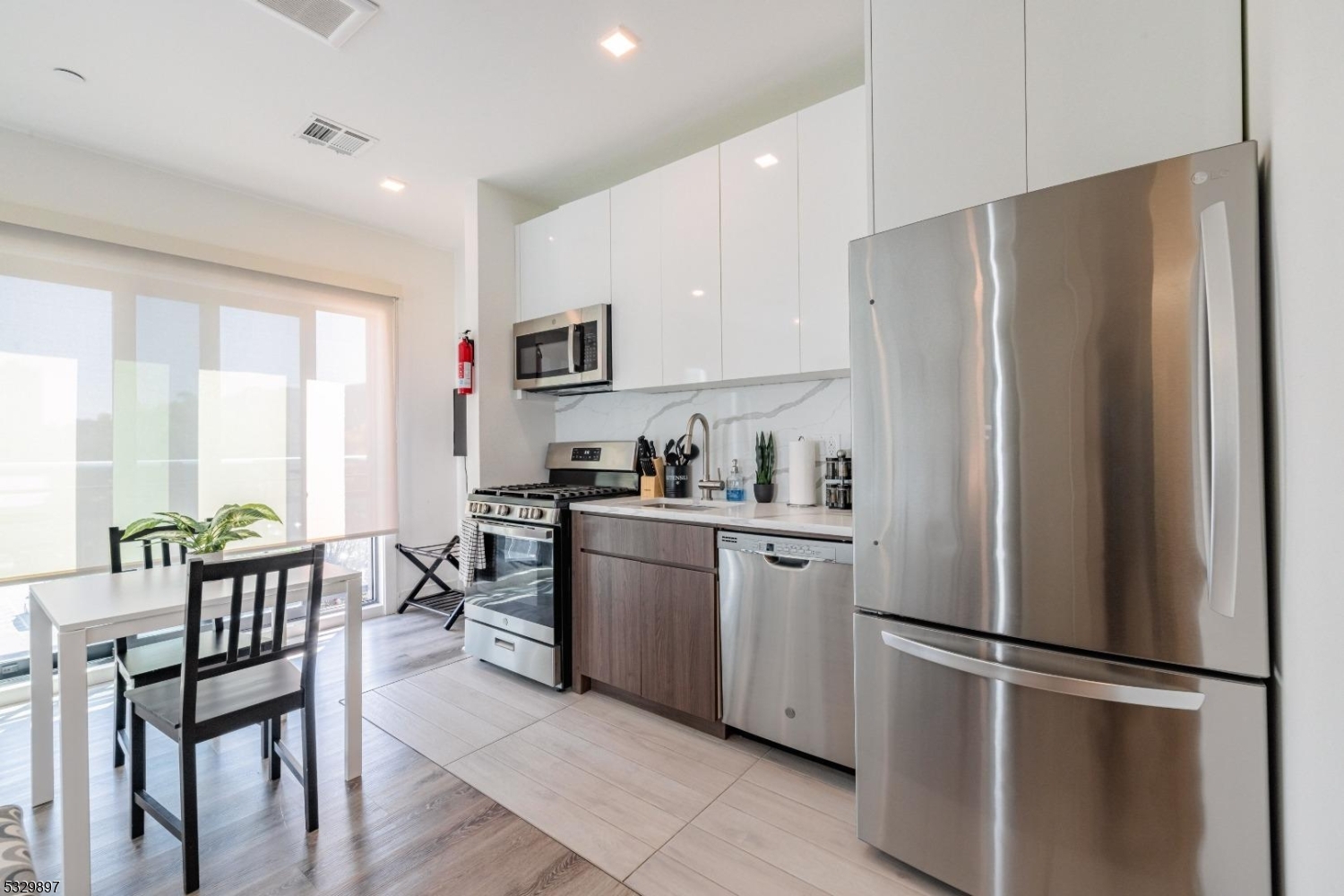 a kitchen with stainless steel appliances a refrigerator sink and white cabinets