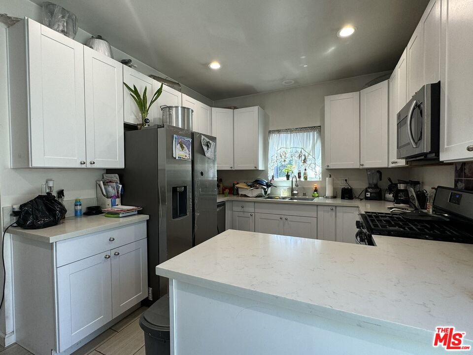 a kitchen with a sink a stove a refrigerator and cabinets