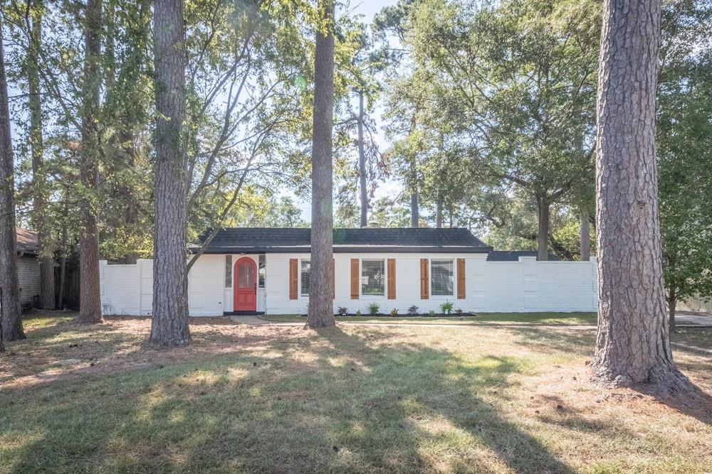 a view of house with backyard and trees