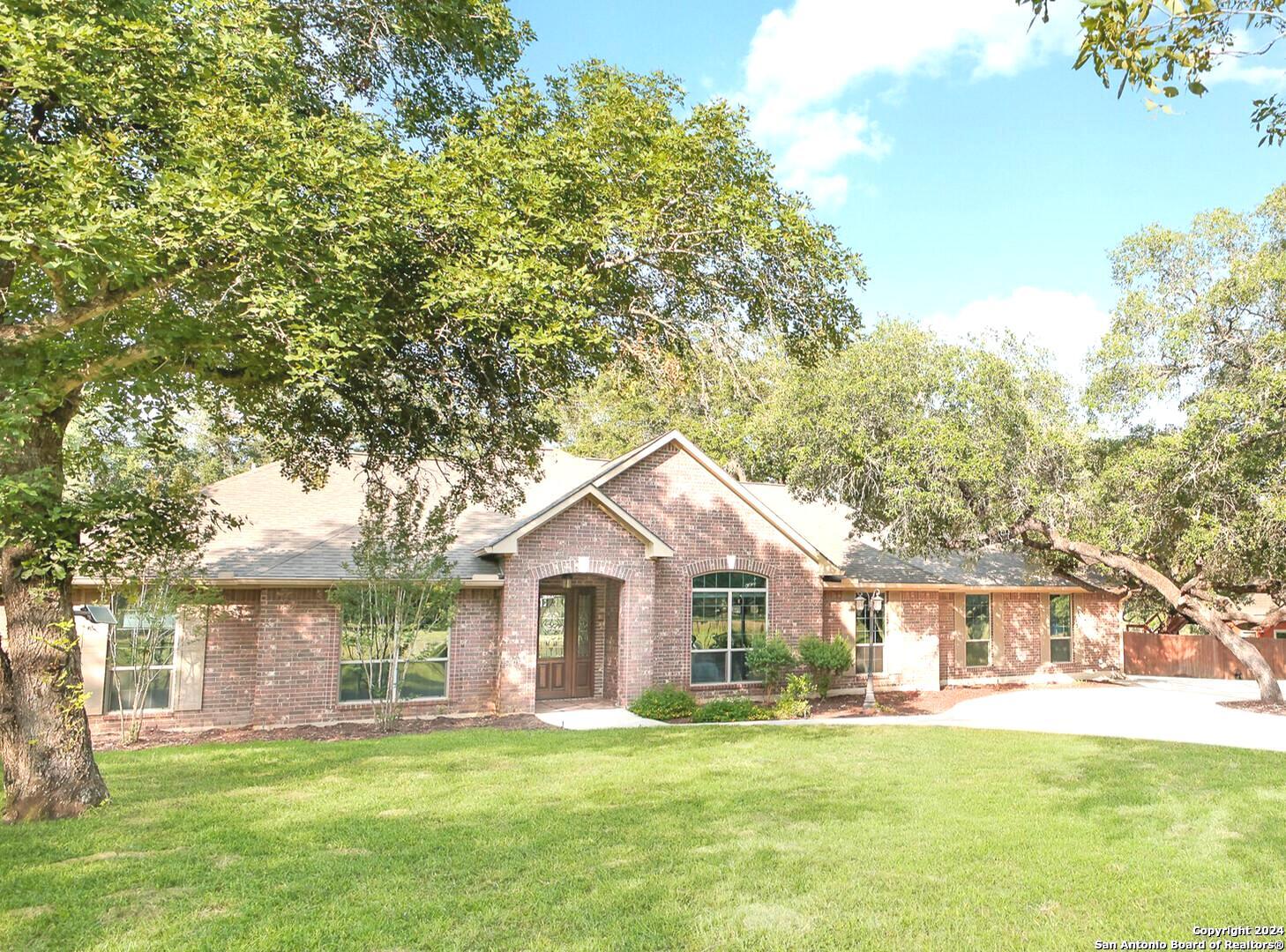 a front view of a house with a yard and trees