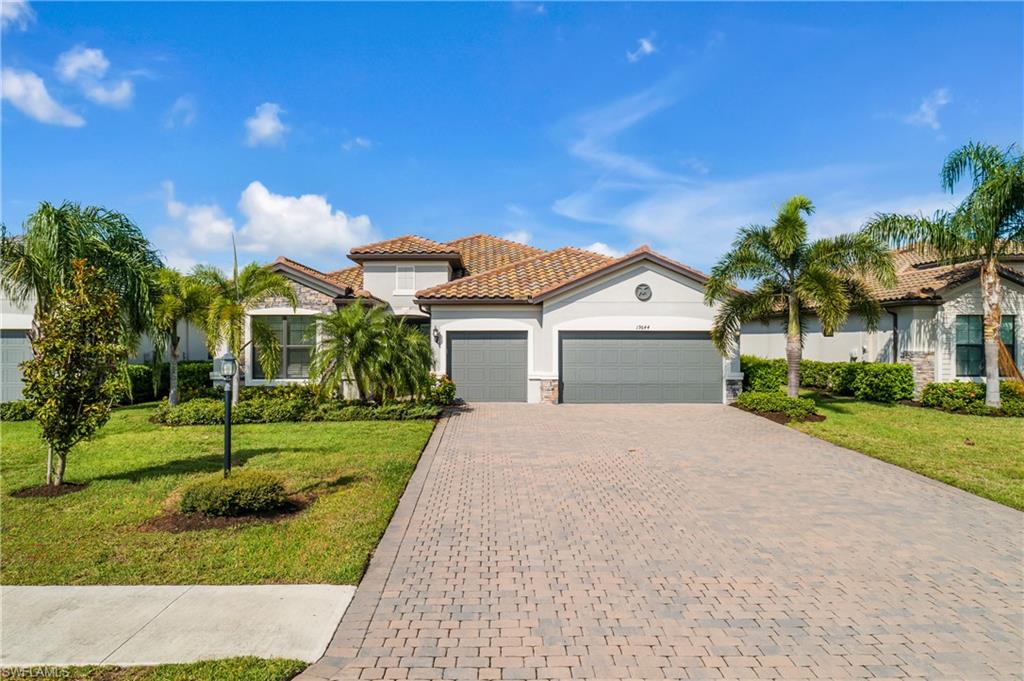 a view of a house with a yard and palm trees