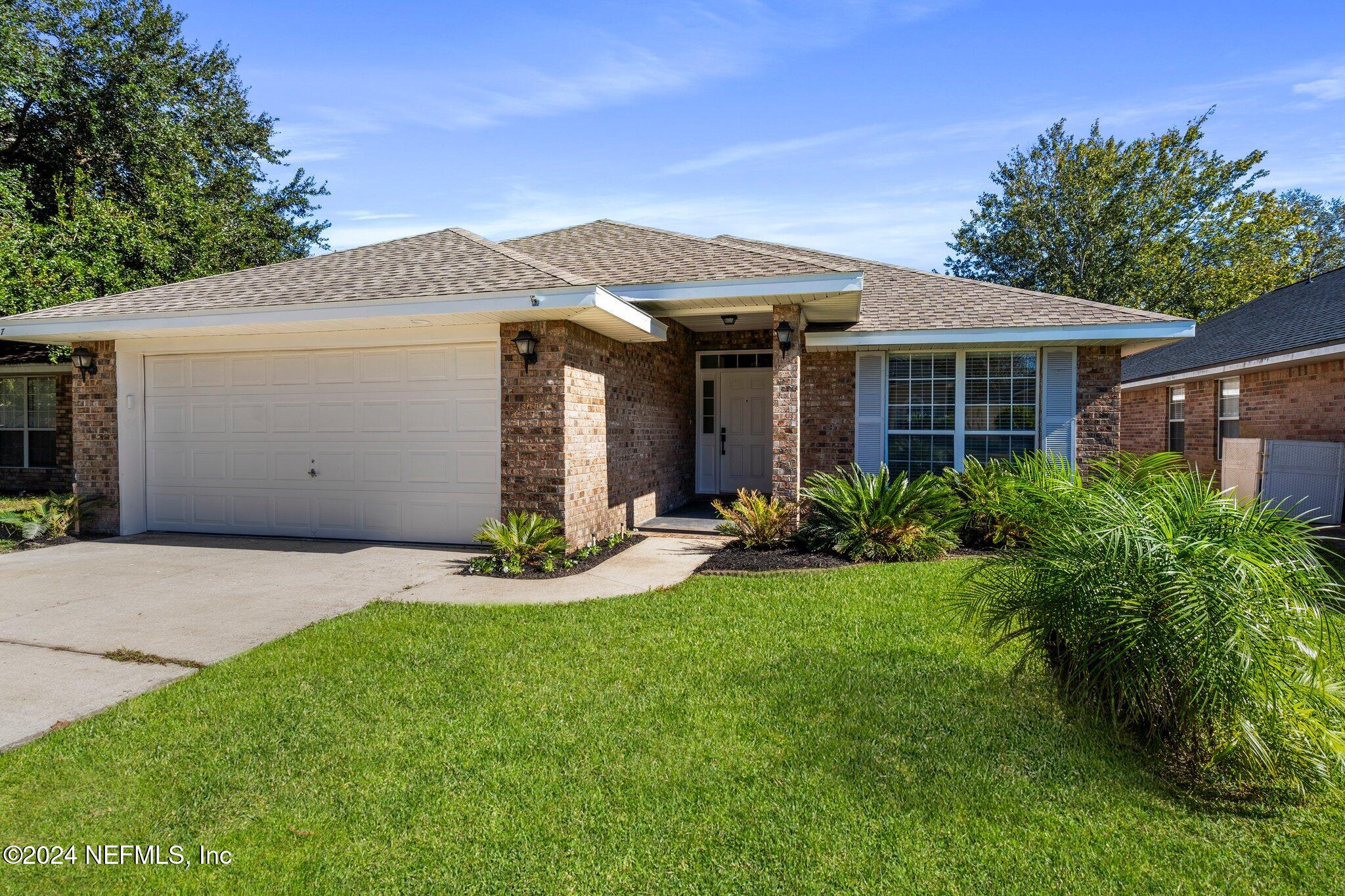 a front view of a house with a yard and garage