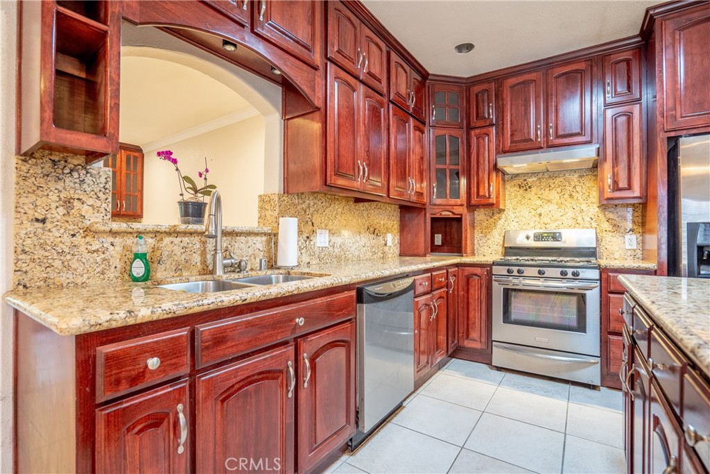 a kitchen with stainless steel appliances granite countertop a sink stove and cabinets