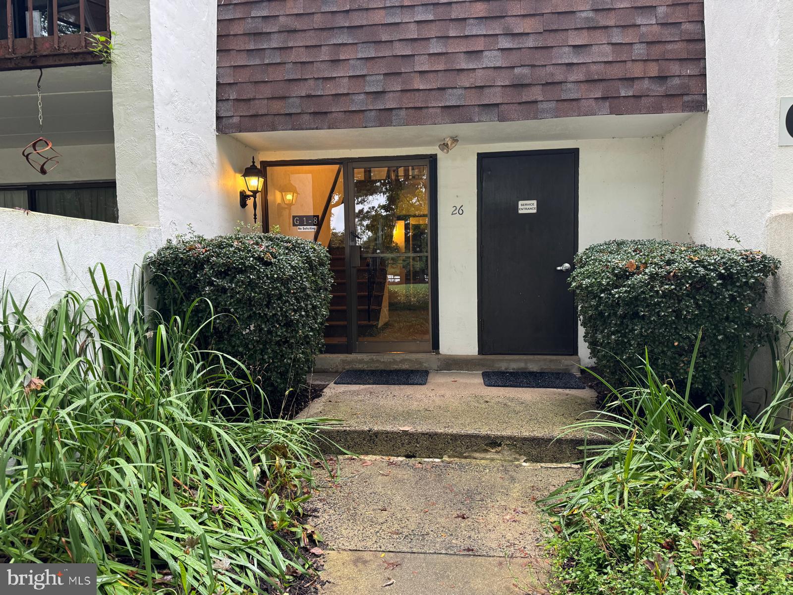 a view of yellow house with potted plants