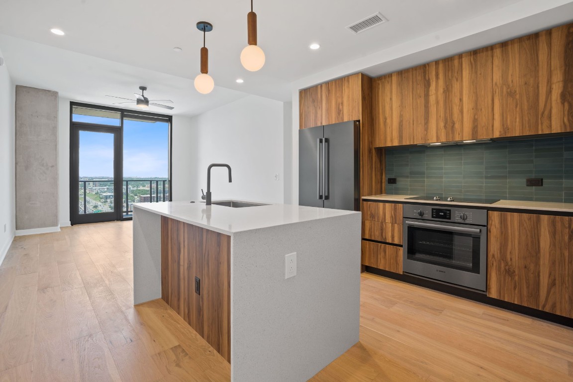 a kitchen with stainless steel appliances granite countertop a sink a stove and a refrigerator