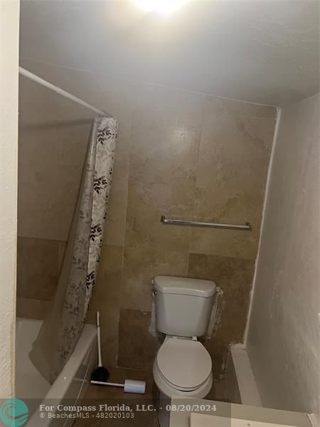 a white toilet sitting next to a shower