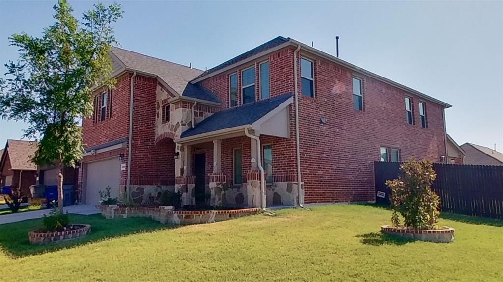 View of side of property featuring a garage and a lawn